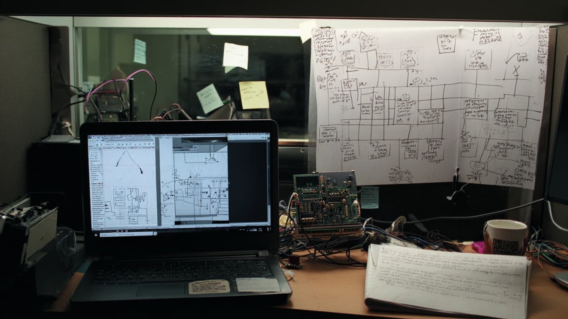 Ingenieur-Arbeitsplatz mit Laptop, Schaltkreisen und handschriftlichen Diagrammen - symbolisiert die technische Seite von KI im E-Commerce